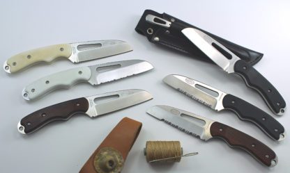 A group of knives and other tools are laying on the table.