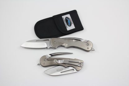 A pair of pocket knives and an opening tool.