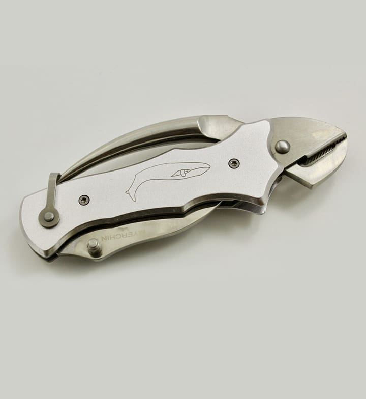 Folding knife with whale engraving on handle.