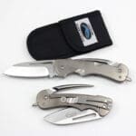 Two folding knives with protective black sheath.