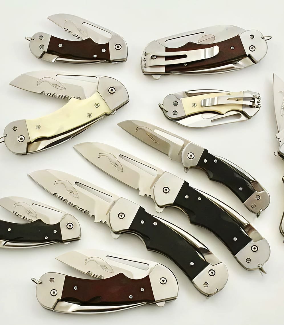 Collection of various folding knives displayed together.