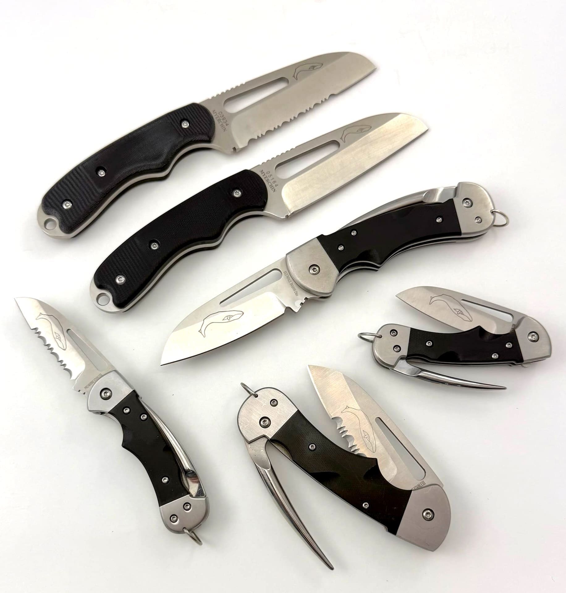 Assorted folding knives with black handles displayed.