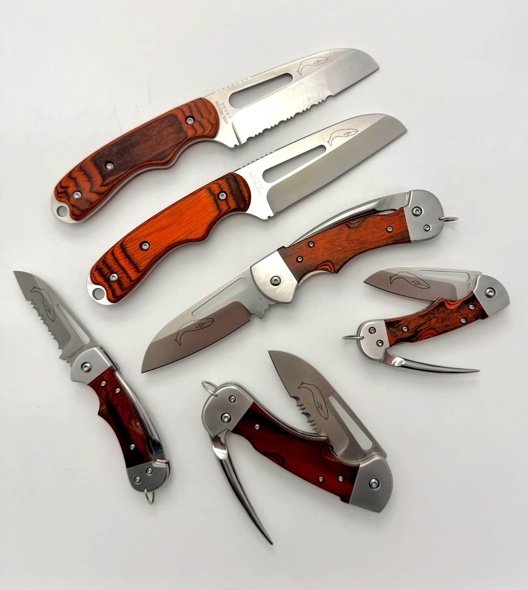 Assorted folding knives with wooden handles displayed.